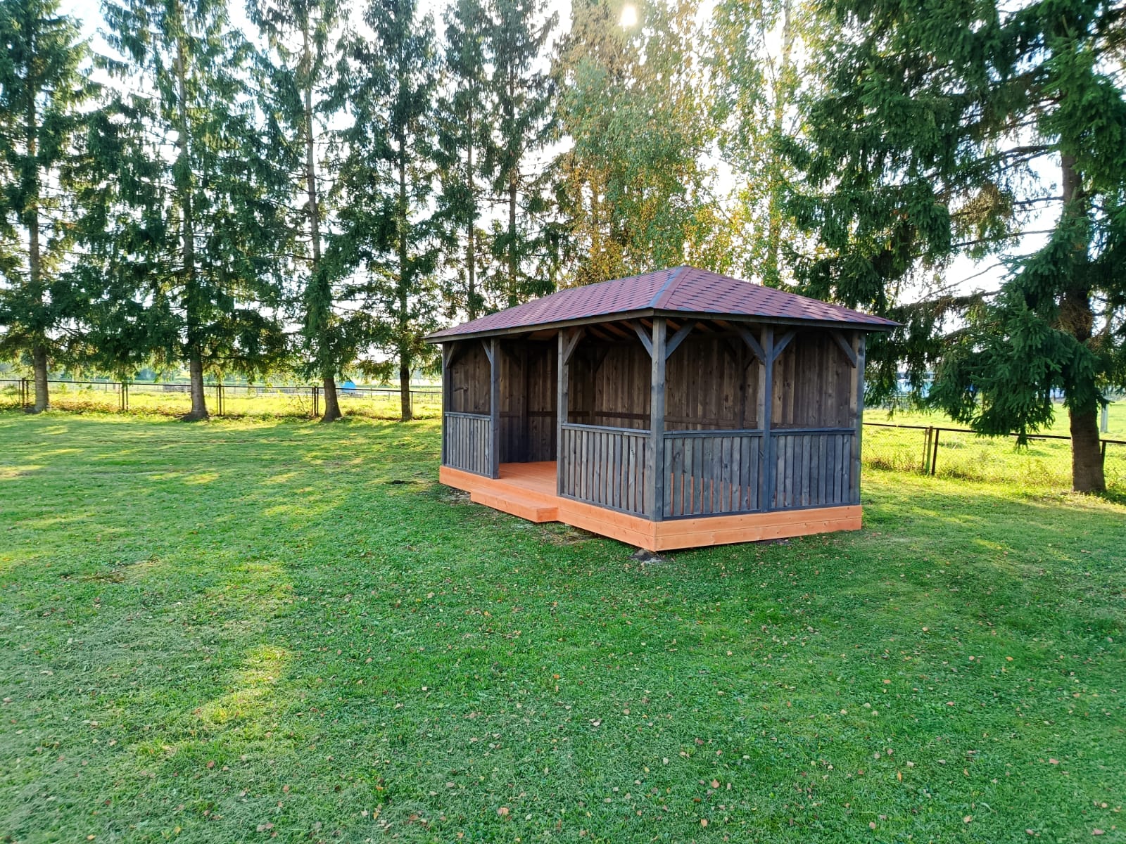 Tumša koka lapene 3x6 m dārzā ar sarkanu šindeļu jumtu